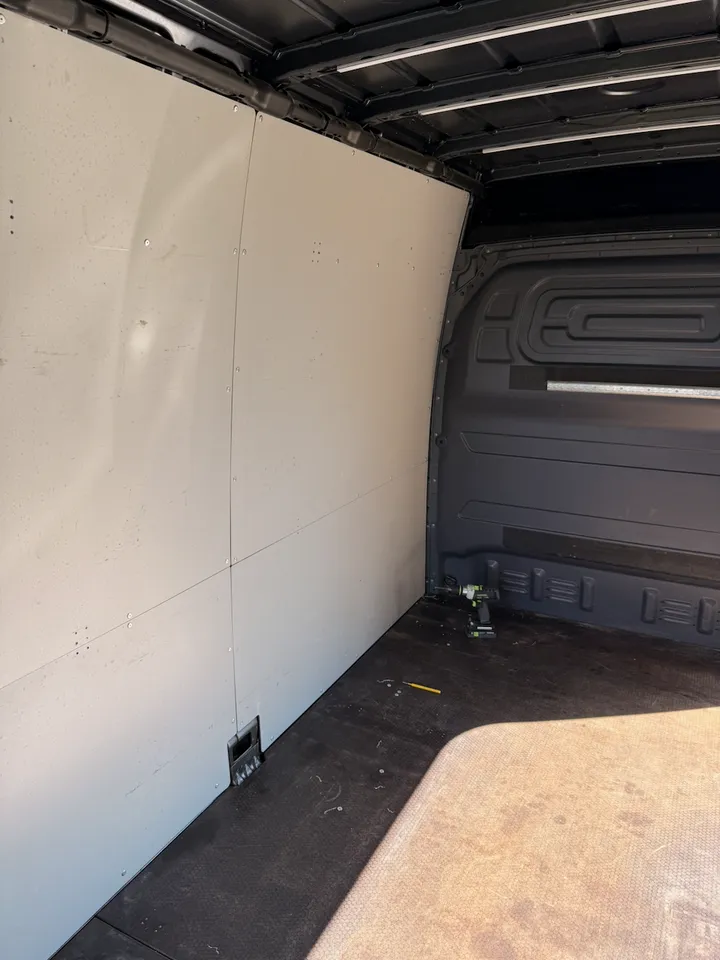 The cargo bay with its grey factory panels, before the first one came off