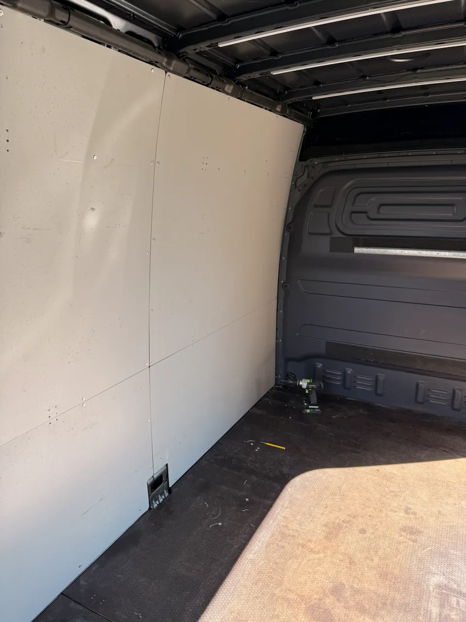 The cargo bay with its grey factory panels, before the first one came off