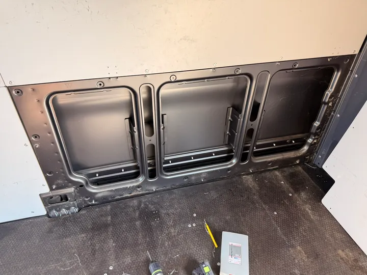 First panel off. Bare metal and a neat row of empty rivet holes.