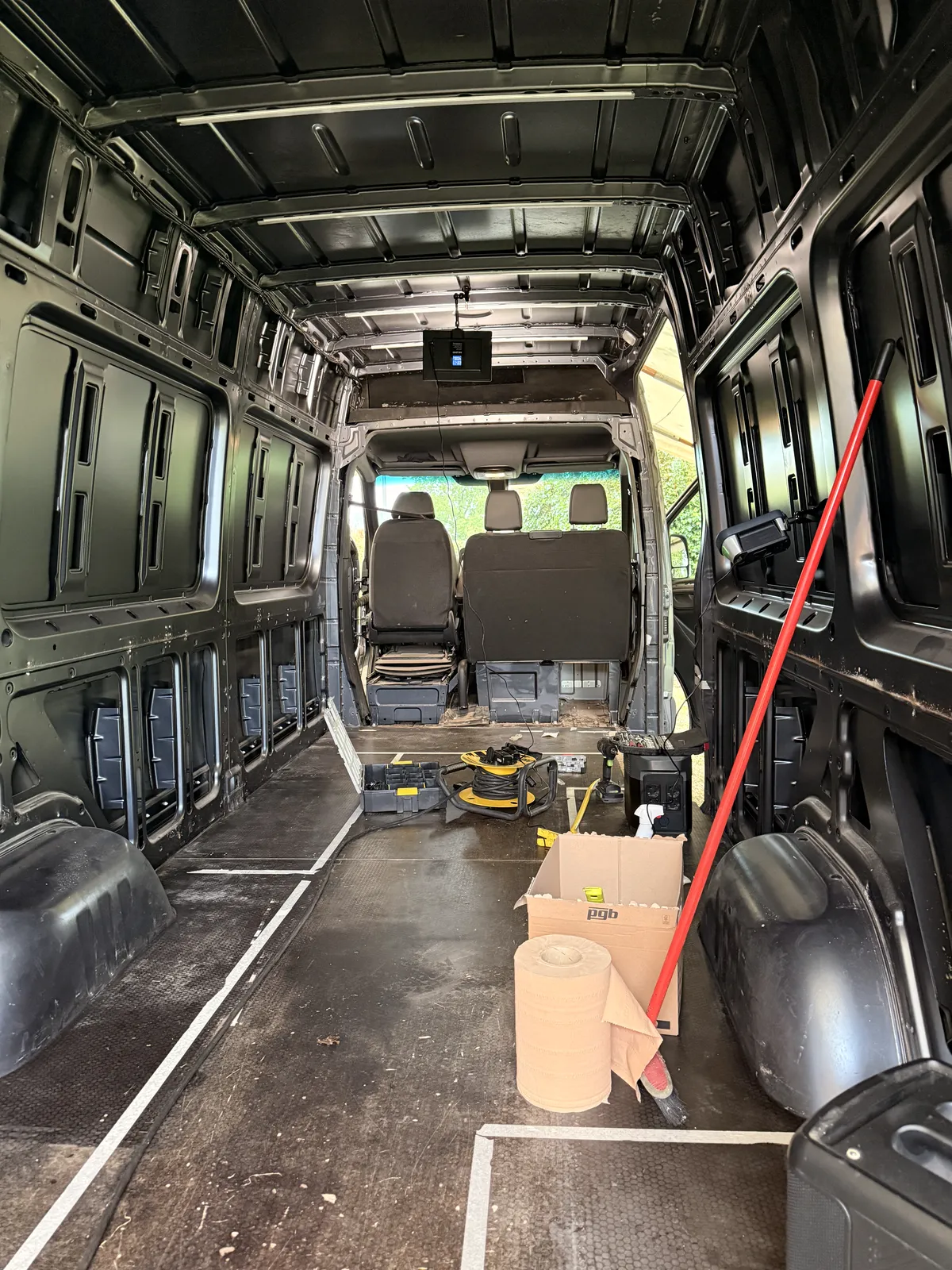 Looking forward through the stripped cargo area with the partition gone and both cab seats in view