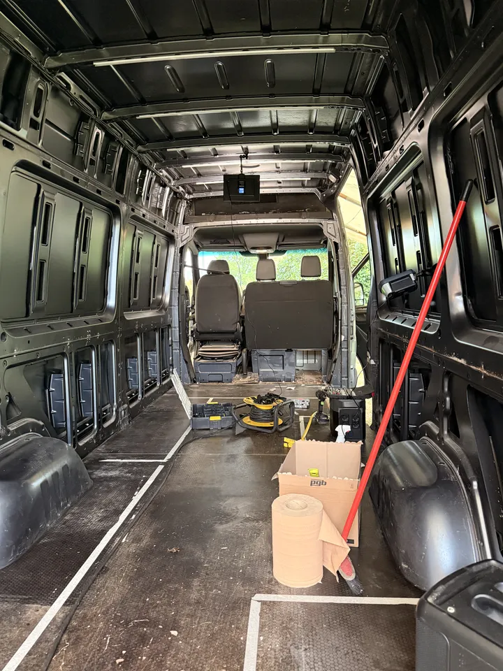 Looking forward through the stripped cargo area with the partition gone and both cab seats in view