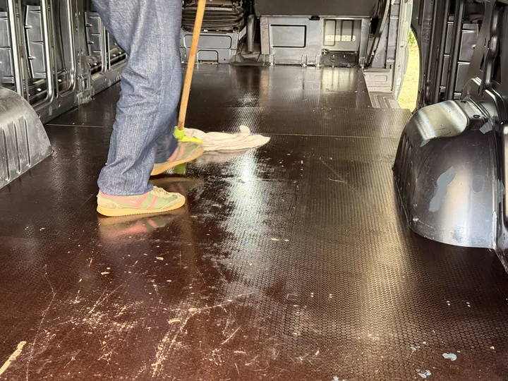 Mopping out the load floor. Everything the stripping left behind has to go before the cork can go on.