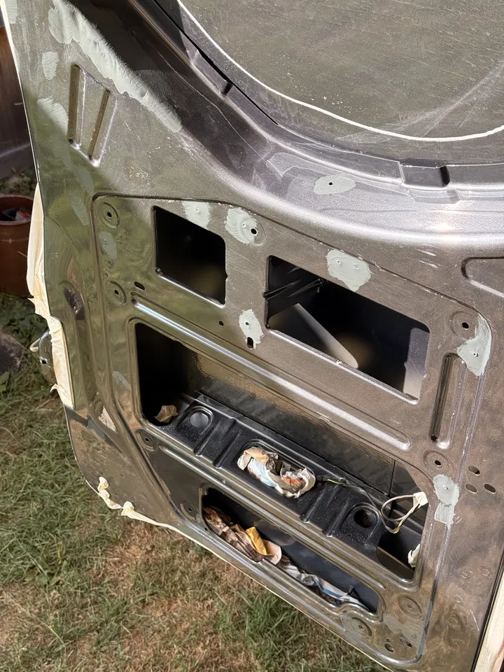 Rear door edges taped off, paint on the scratches, paper in the openings.